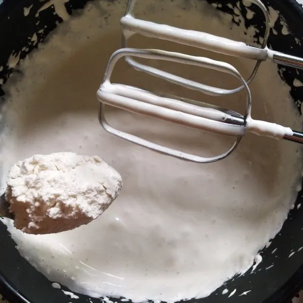 Masukkan tepung terigu yang sudah diayak sedikit demi sedikit sambil di mixer menggunakan speed rendah.
