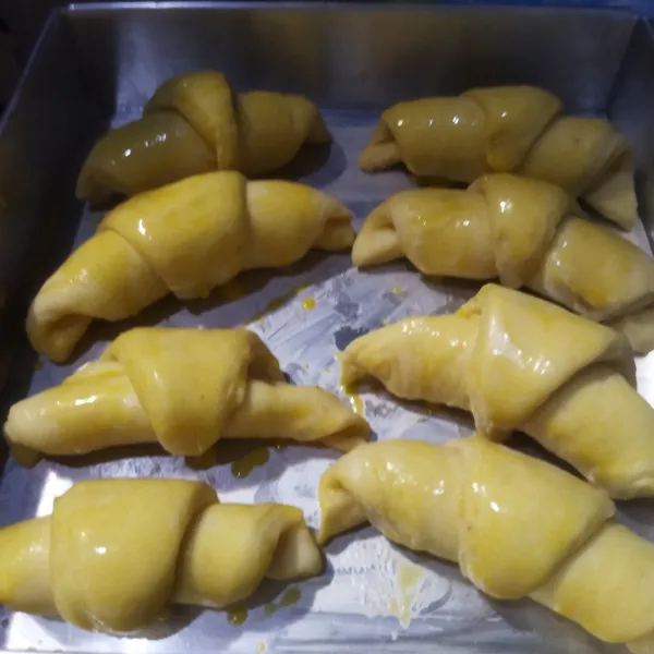 Lalu tutup dengan serbet, biarkan hingga croissant mengembang 2 kali. Setelah adonan mengembang, oles croissant dengan bahan olesan.