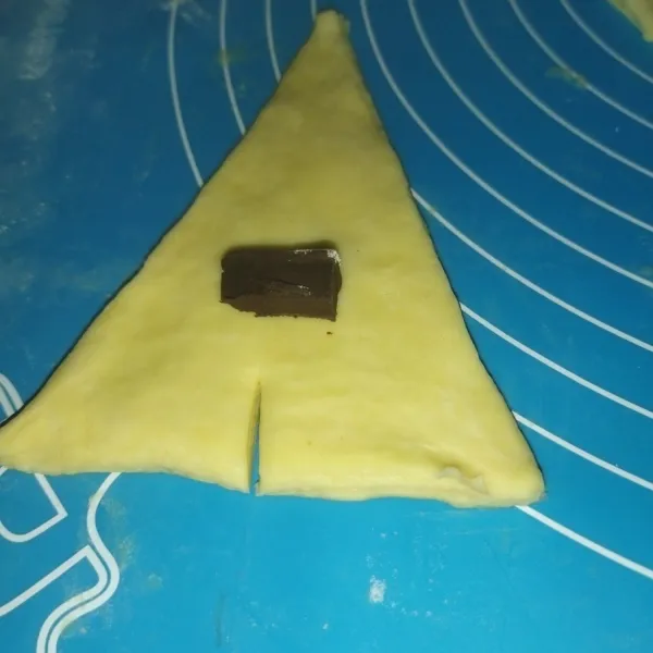 Lalu yang 1 bagian lagi, adonannya dipipihkan, lalu potong seperti membentuk segitiga sama kaki, lalu taruh isian secukupnya, potong sedikit bagian bawah segitiga, lalu gulung dari bawah keatas, lalu tata croissant di atas loyang.