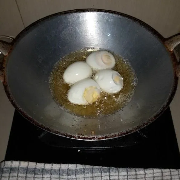 Panaskan minyak goreng, goreng telur hingga kulit berwarna kecoklatan. Angkat dan tiriskan.