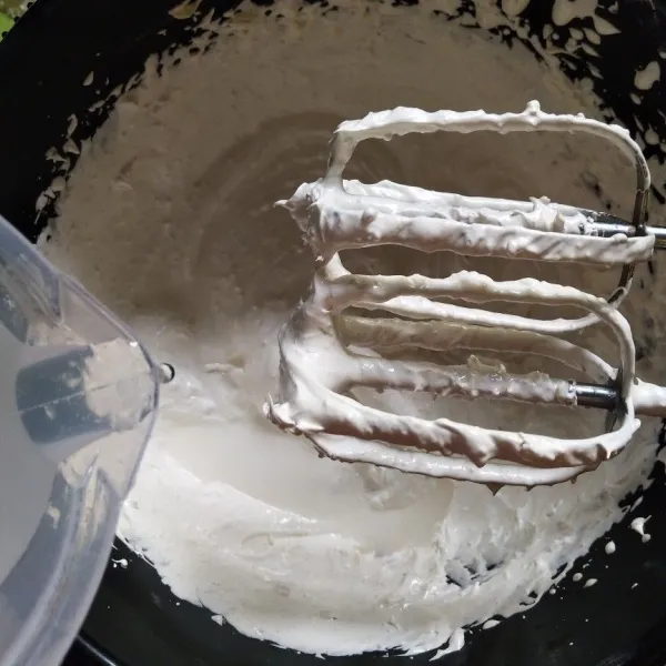 Masukkan air kelapa sedikit demi sedikit sambil di mixer, masih menggunakan speed tinggi.