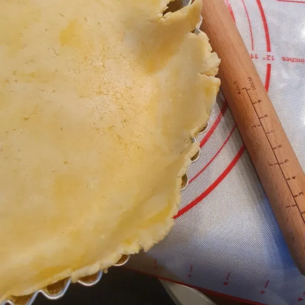 Gilas, cetak ke dalam cetakan pie. Tusuk permukaannya dengan garpu, supaya saat dipanggang permukaan tidak menggelembung.