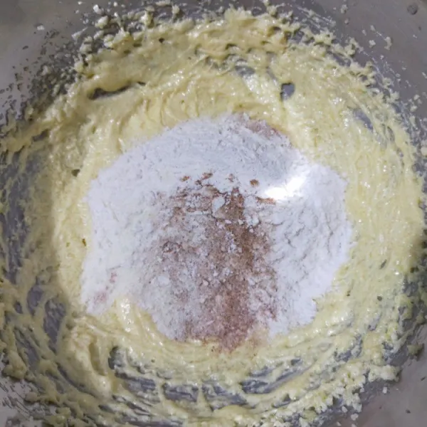 Masukkan tepung terigu, baking powder, garam, dan kayu manis bubuk sambil di ayak. Aduk rata dengan spatula.