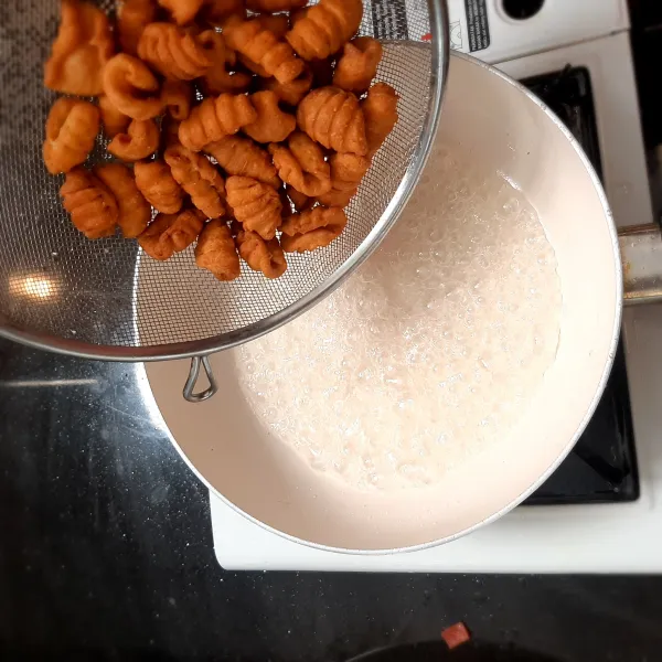 Terakhir, masukkan bahan sugar coated nya yaitu air dan gula sampai kental. Setelah kental, masukkan kue kering tadi yang sudah kita goreng sampai terlapisi dengan gula.