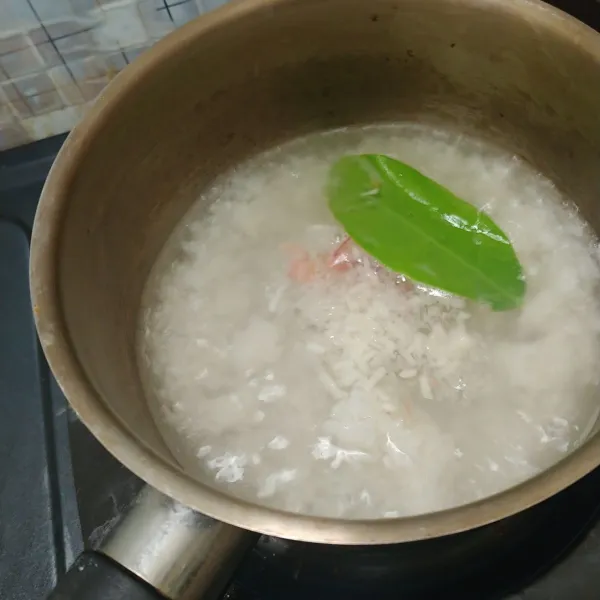 Panaskan air sebanyak 200 ml dulu lalu masukkan nasi, bawang dan daun salam. Masak sampai mendidih.