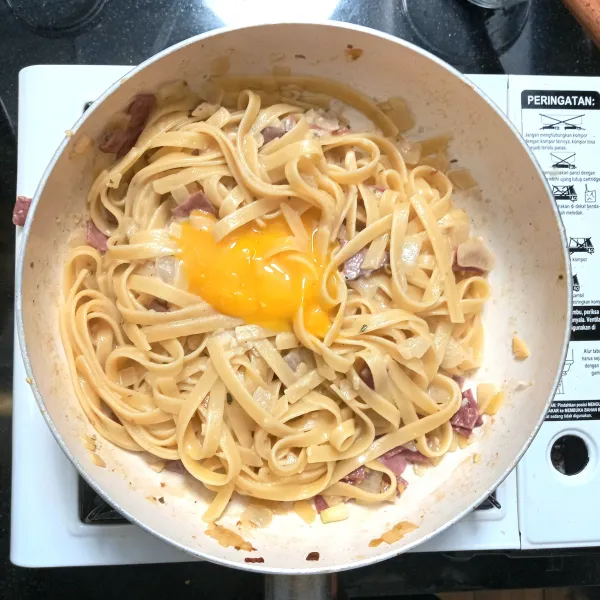 Matikan api, lalu masukkan kuning telur. Aduk dengan cepat agar kuning telur tidak matang.