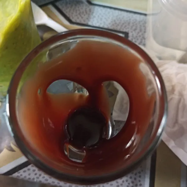 Tuang susu kental manis rasa cokelat di pinggiran gelas saji.