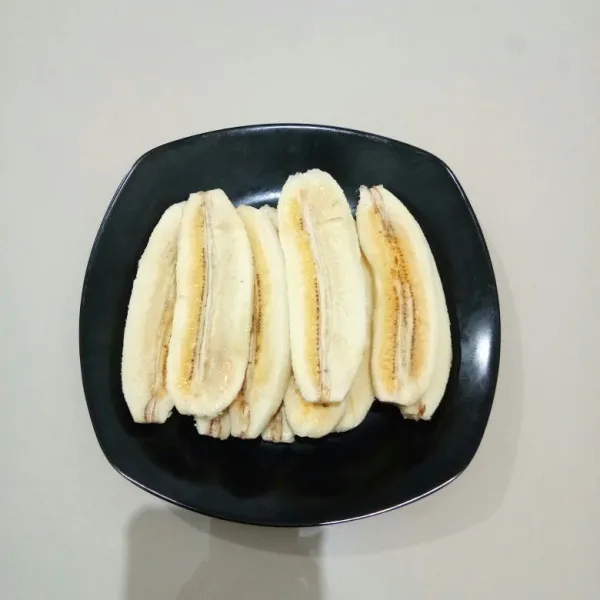 Kupas pisang, belah memanjang menjadi 2 bagian.