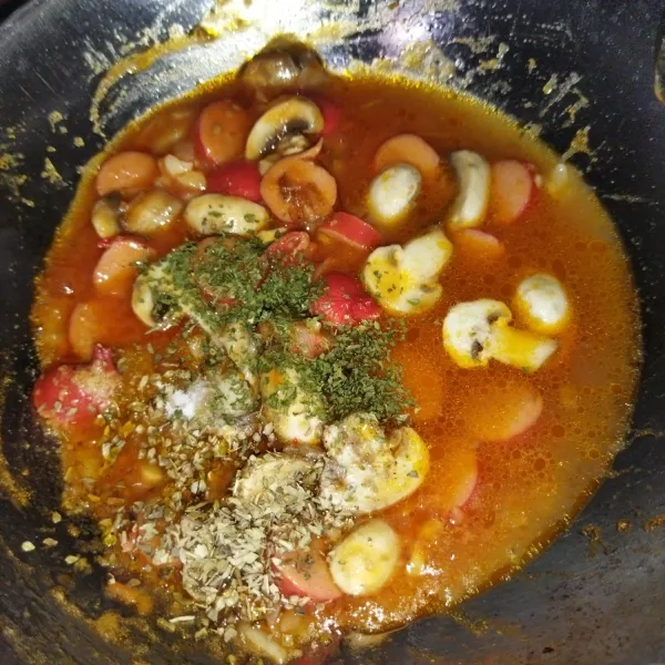 Lalu masukkan sosis, jamur dan aduk rata. Lalu masukkan garam, kaldu bubuk, lada bubuk, parsley, oregano dan 50 ml sisa air rebusan tomat tadi.
