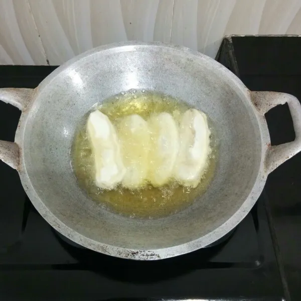 Lalu goreng pisang dalam minyak panas hingga kedua sisinya matang, kemudian tiriskan.