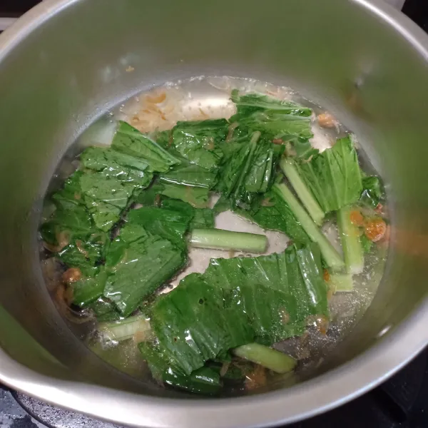 Didihkan air, tambahkan bawang goreng, masak sawi hijau sampai empuk. Tambahkan bakso dan tauge sebentar lalu masukkan dalam mangkuk.