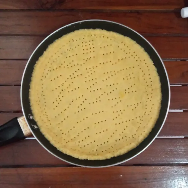 Olesi teflon dengan mentega tipis-tipis, lalu masukkan adonan pie, ratakan kemudian tusuk-tusuk dengan garpu.