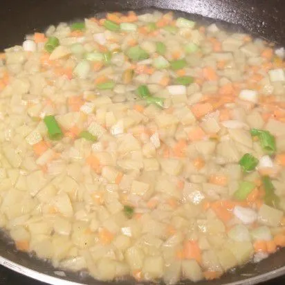 Tuang air secukupnya. Masukkan wortel, kentang dan daun bawang. Aduk rata. Masak sampai wortel kentang empuk. Tambahkan garam, merica bubuk, dan kaldu bubuk. Aduk rata.