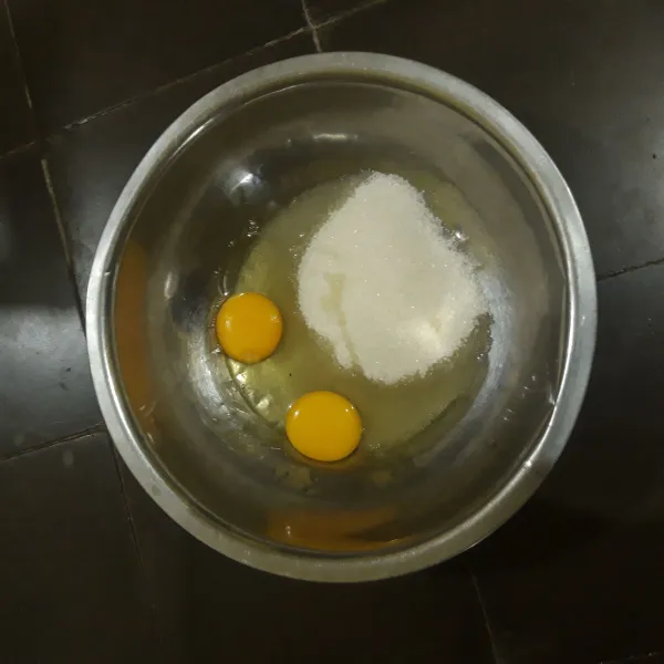 Masukkan telur dan gula dalam wadah, aduk dengan whisk.