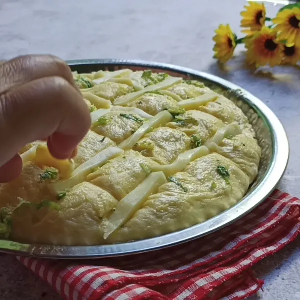 Beri potongan keju mozzarella di sela-sela keratan roti.