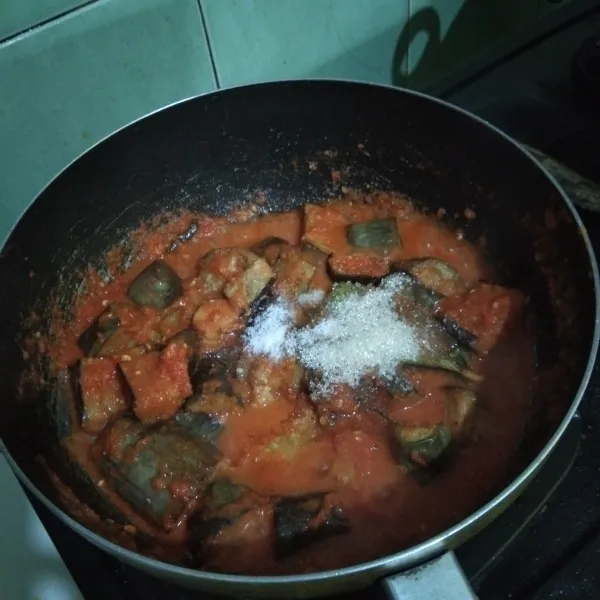 Masukan terong yang sudah digoreng tadi, aduk-aduk bersama bumbunya. Kemudian masukan garam, penyedap rasa, gula pasir dan gula merahnya. Aduk-aduk kembali hingga bumbu meresap