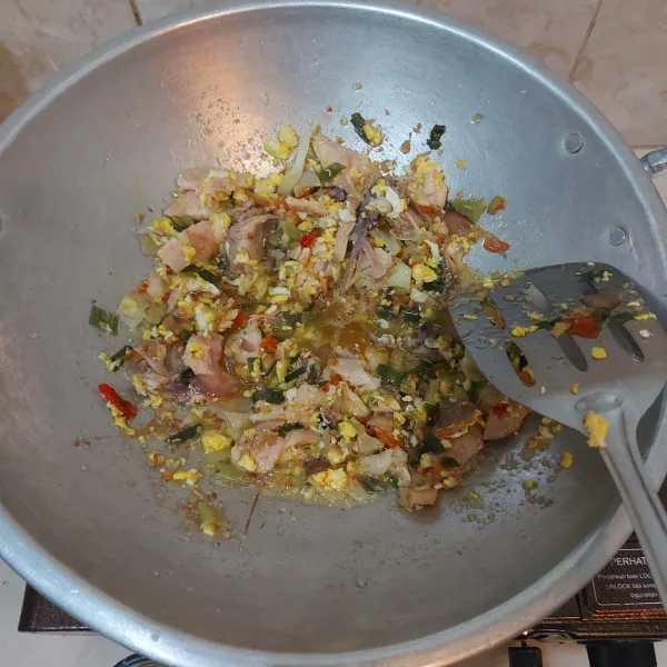 Tumis semua bumbu halus tadi kemudian masukkan telur, sawi, irisan daun bawang dan suiran ayam rebus. Terakhir masukkan mie yang sudah dicampur bersama saos.