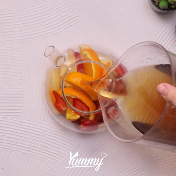 Susun buah-buahan ke dalam teko dan siram dengan jasmine tea.