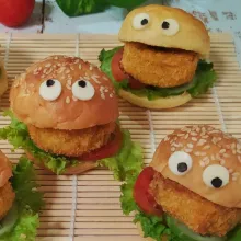 Belah roti, beri daun selada, irisan tomat dan timun serta nugget. Hias dengan keju slice dan nori untuk membuat mata.