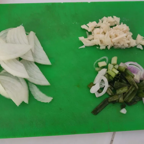 Cincang bawang putih, iris tipis bawang bombay dan potong kasar daun bawang, sisihkan.