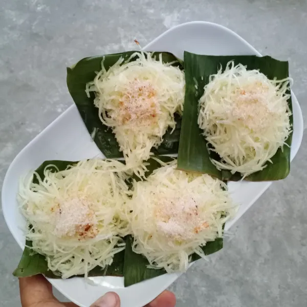 Sajikan singkong dengan taburan kelapa parut dan gula pasir.