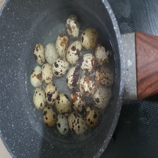 Rebus telur puyuh, jika sudah matang kupas telur puyuh dan sisihkan.
