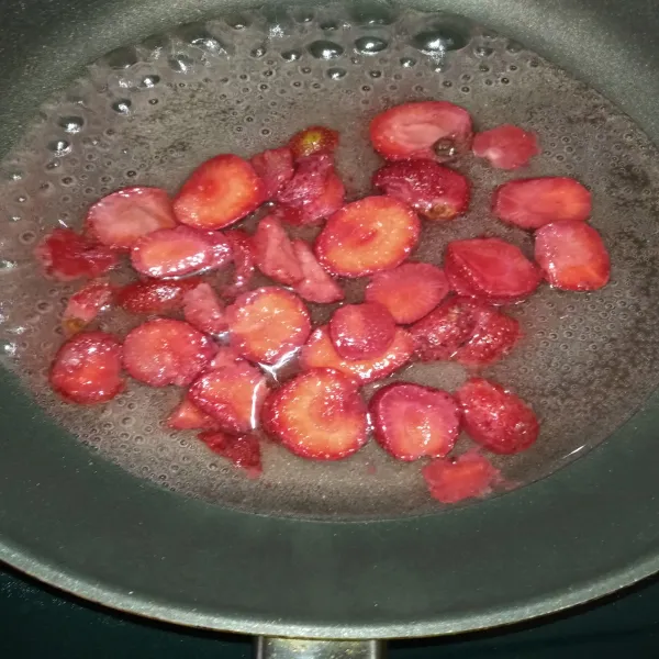 Masak strawberry, air dan gula hingga strawberry lunak dan air menyusut. Terus diaduk agar tidak hangus. Gunakan api kecil.