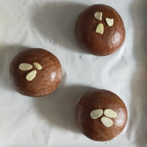 Panaskan oven di suhu 180'C. Olesi permukaan dough dengan susu cair, lalu hias dengan almond slice. Lalu panggang selama 15 menit atau sampai matang. Sesuaikan dengan oven masing-masing.