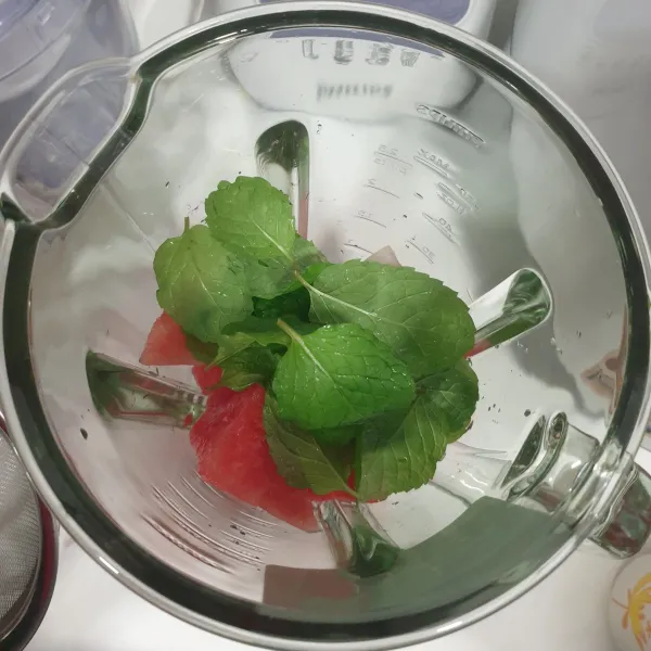 Siapkan blender, masukkan potongan semangka dan daun mint.