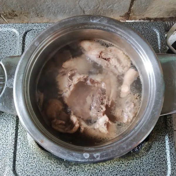 Rebus tulang dan daging ayam hingga mendidih.