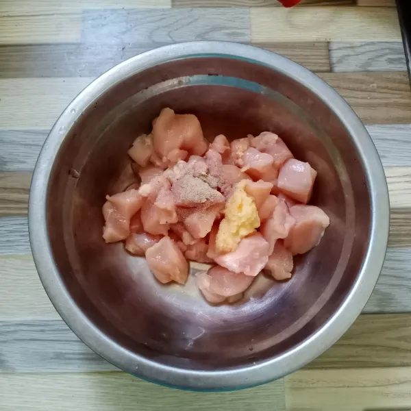 Potong dadu ayam, kemudian campur rata dengan bawang putih halus, garam dan lada bubuk. Diamkan selama 10 menit.