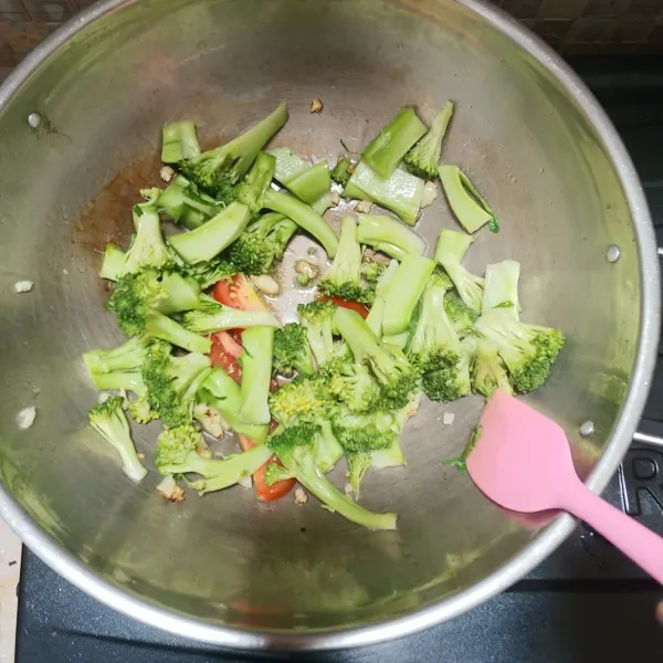Tumis bawang putih dan tomat hingga layu dan wangi, masukkan brokoli, tambahkan sedikit air.