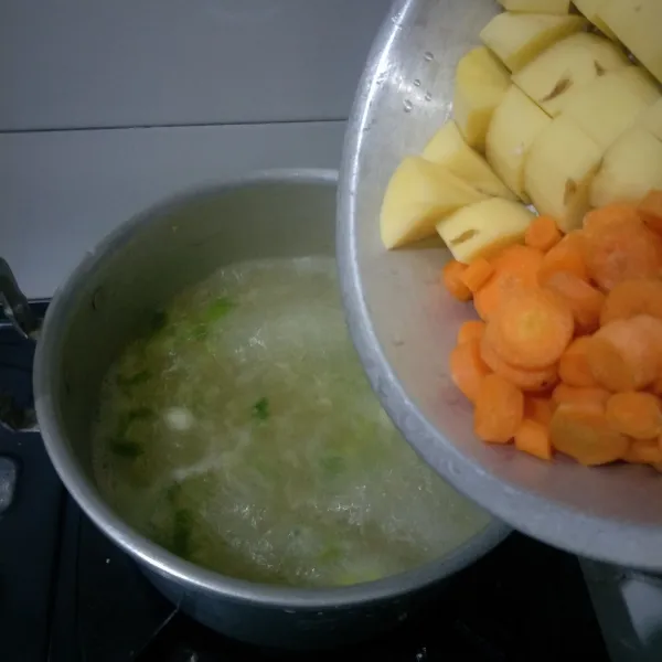 Masukkan wortel dan kentang, tunggu sampai setengah matang.