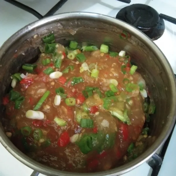 Masukkan irisan daun bawang, aduk rata, lalu matikan kompor.
