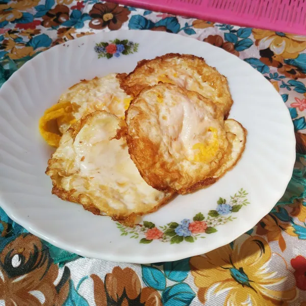 Goreng telur ayam dengan cara diceplok, Taburi sedikit garam.