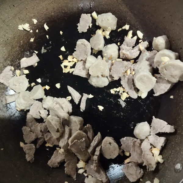 Tumis bawang putih cincang dengan minyak wijen, hingga harum. Masukkan daging iris dan bakso.