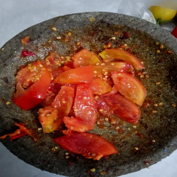 Ulek kasar tomat, cabai rawit, bawang merah, lalu beri sedikit garam, minyak sayur dan gula