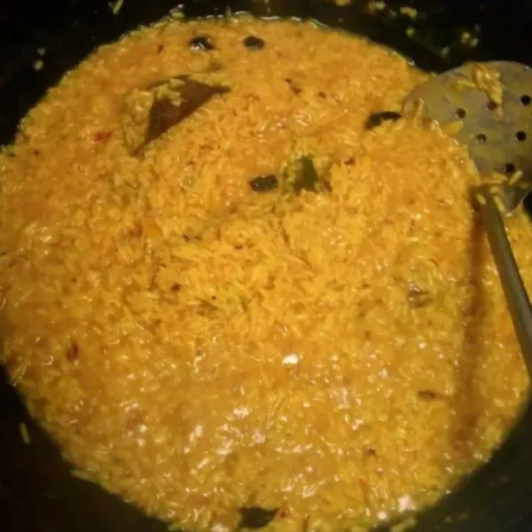 Masukkan rendaman beras ke dalam sisa rebusan ayam, aduk rata, masak hingga matang dan air asat.