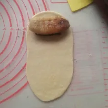 Ambil satu bulatan, pipihkan membentuk lonjong. Taruh selai cokelat dan timpa dengan pisang di atasnya.