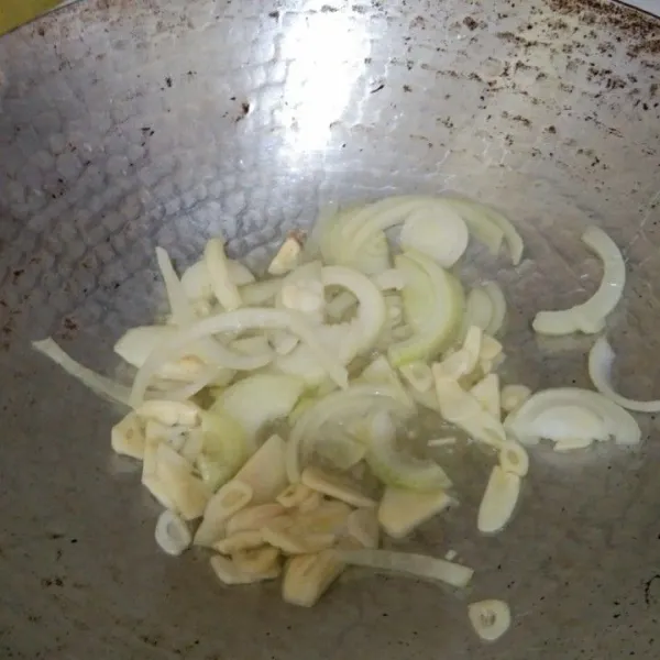 Tumis irisan bawang putih dan bawang bombay hingga harum