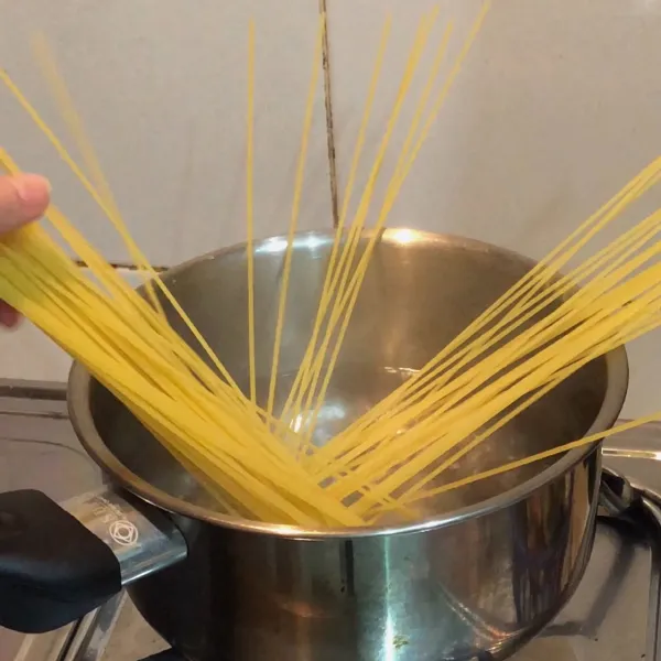 Rebus spaghetti di air mendidih yang sudah di beri garam.