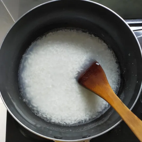 Masak beras dengan 2 gelas air, masak sampai air hampir habis.