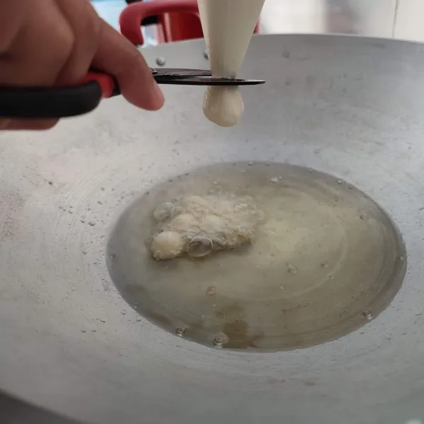 Panaskan minyak, gunting ujung plastik segitiga. Keluarkan adonan sedikit kemudian gunting dan goreng.