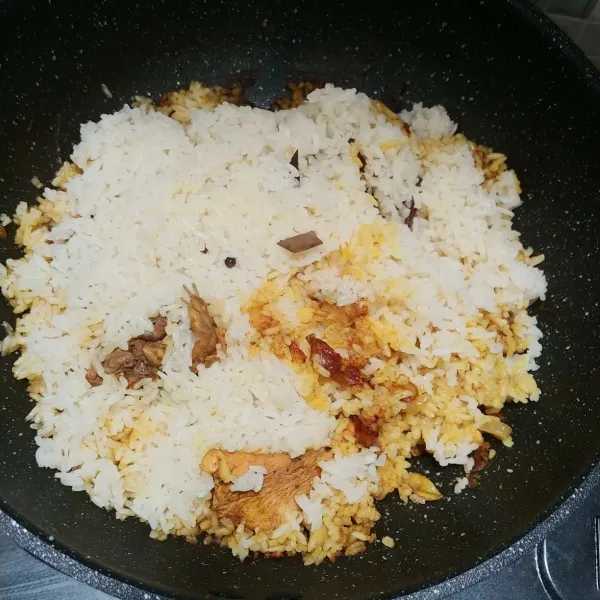 Masukan nasi di atas ayam, sebaiknya jangan diaduk. Biarkan saja sampai nasi matang merata dan jangan lupa di tutup dan gunakan api kecil