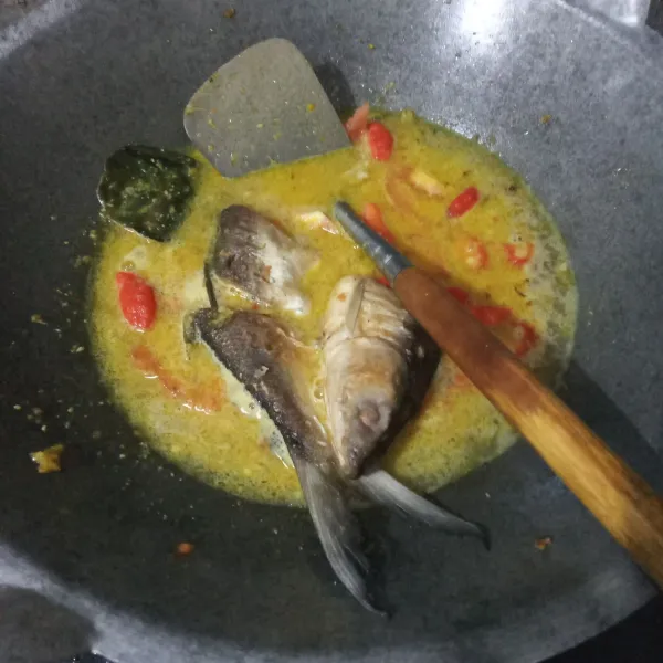 Masukkan ikan bandeng. Aduk rata lalu tutup wajan.