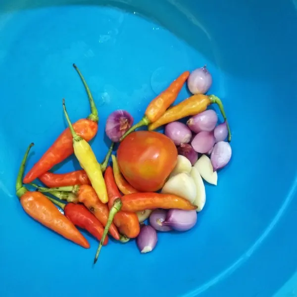 Cuci bersih bawang merah, bawang putih, cabai dan tomat, lalu iris tipis.
