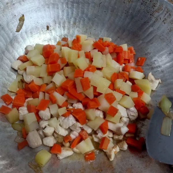 Masukkan kentang dan wortel, aduk rata.
