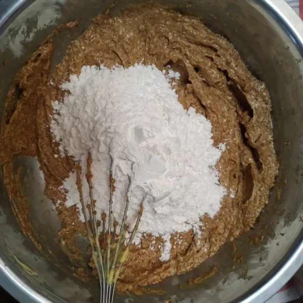 Tambahkan tepung terigu, tepung maizena, baking powder, dan vanili sedikit demi sedikit sambil diaduk hingga tercampur rata.