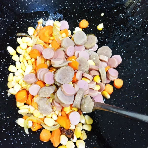 Masukkan jagung, sosis, bakso dan  wortel ke dalam tumisan sebentar supaya tidak berbau langu wortelnya