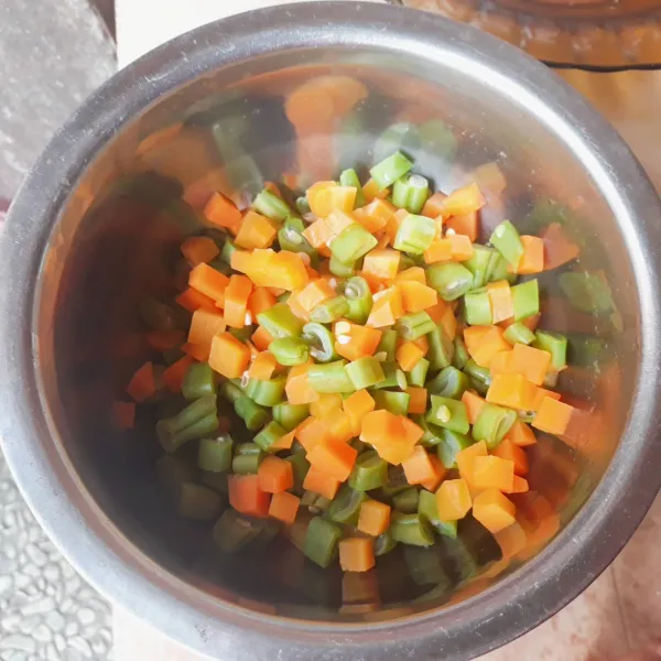 Kupas wortel dan potong dadu. Potong - potong buncis. Cuci bersih wortel dan buncis, tiriskan. Rebus wortel dan buncis dalam air mendidih selama 5 menit, tiriskan.